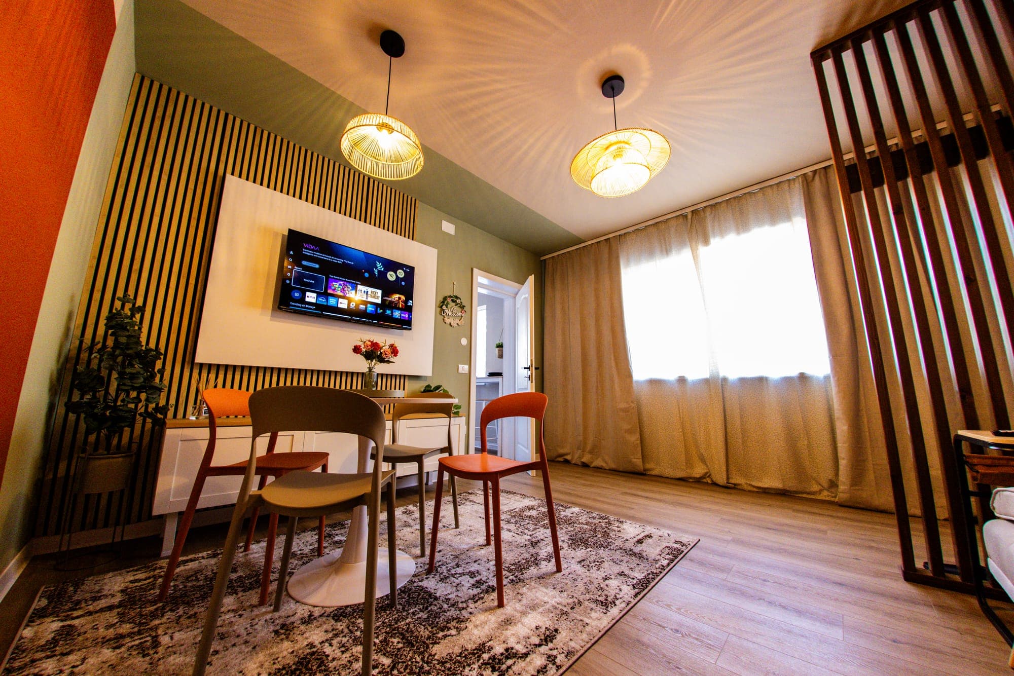 Livingul apartamentului Citadel Garden, cu perete din lamele de lemn, Smart TV și zonă de dining